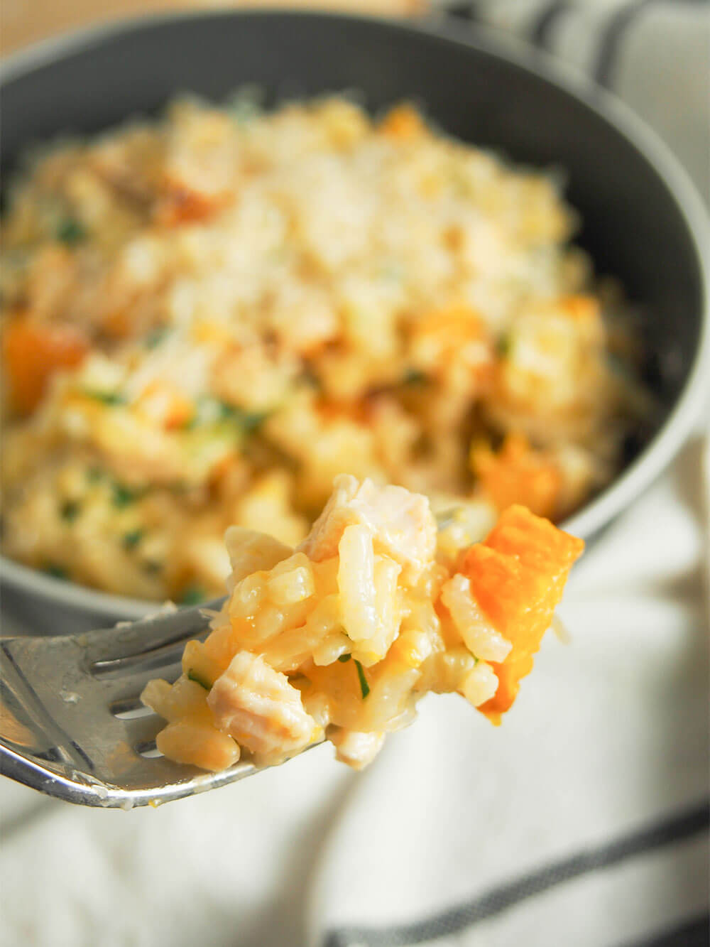 forkful of butternut squash risotto with chicken in front of bowl
