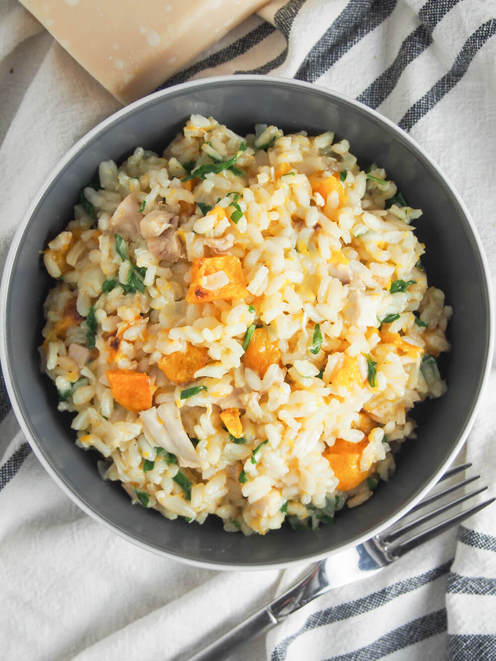 bowlful of butternut squash risotto with chicken and arugula viewed from overhead