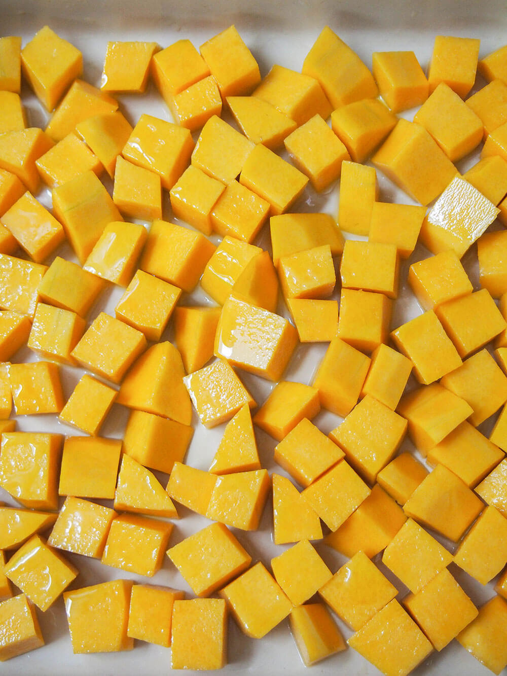 cubes of squash in baking dish ready to roast for risotto