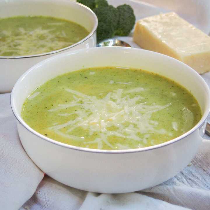 bowl of pumpkin broccoli soup with cheddar with second bowl behind