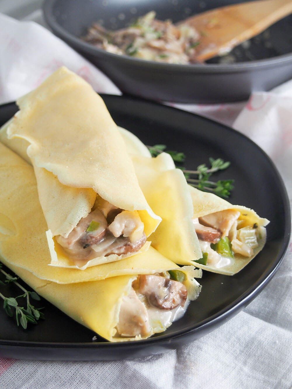 These turkey or chicken crepes with leek and mushrooms are a great way to use leftover meat in a tasty comforting dish. Chicken crepes with leek and mushroom stacked on plate