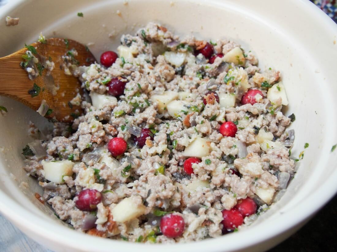 mixing pear, cranberry and sausage stuffing