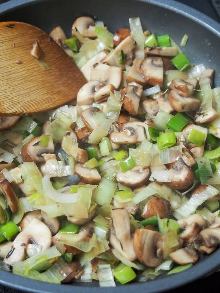 cooking leek and mushrooms in skillet for chicken crepes cooking leek and mushrooms in skillet