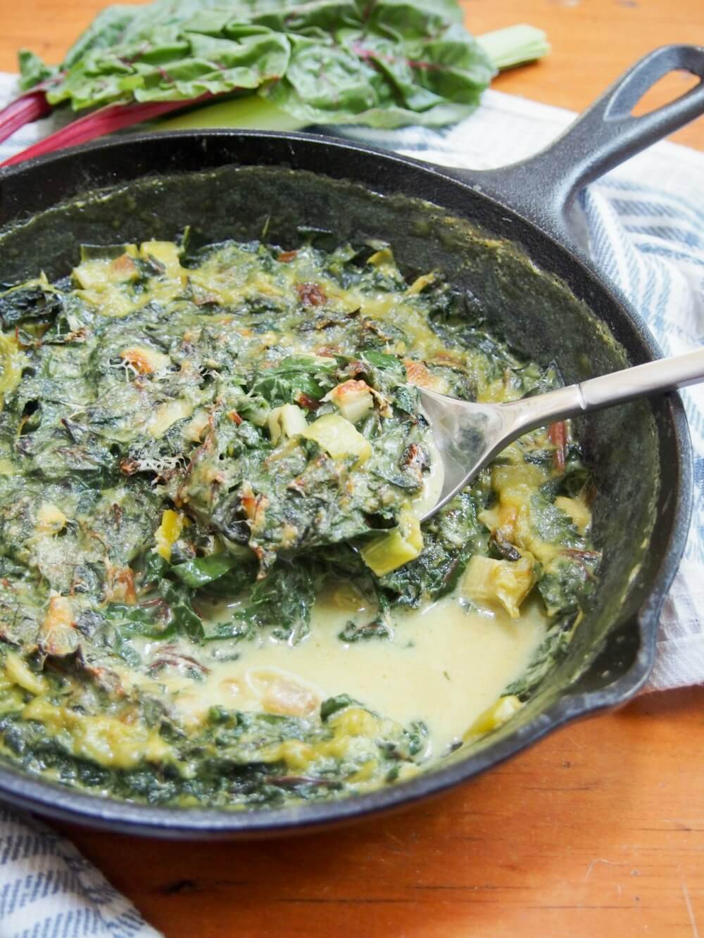 Leek and Swiss chard gratin with spoonful taken from it resting on top of rest