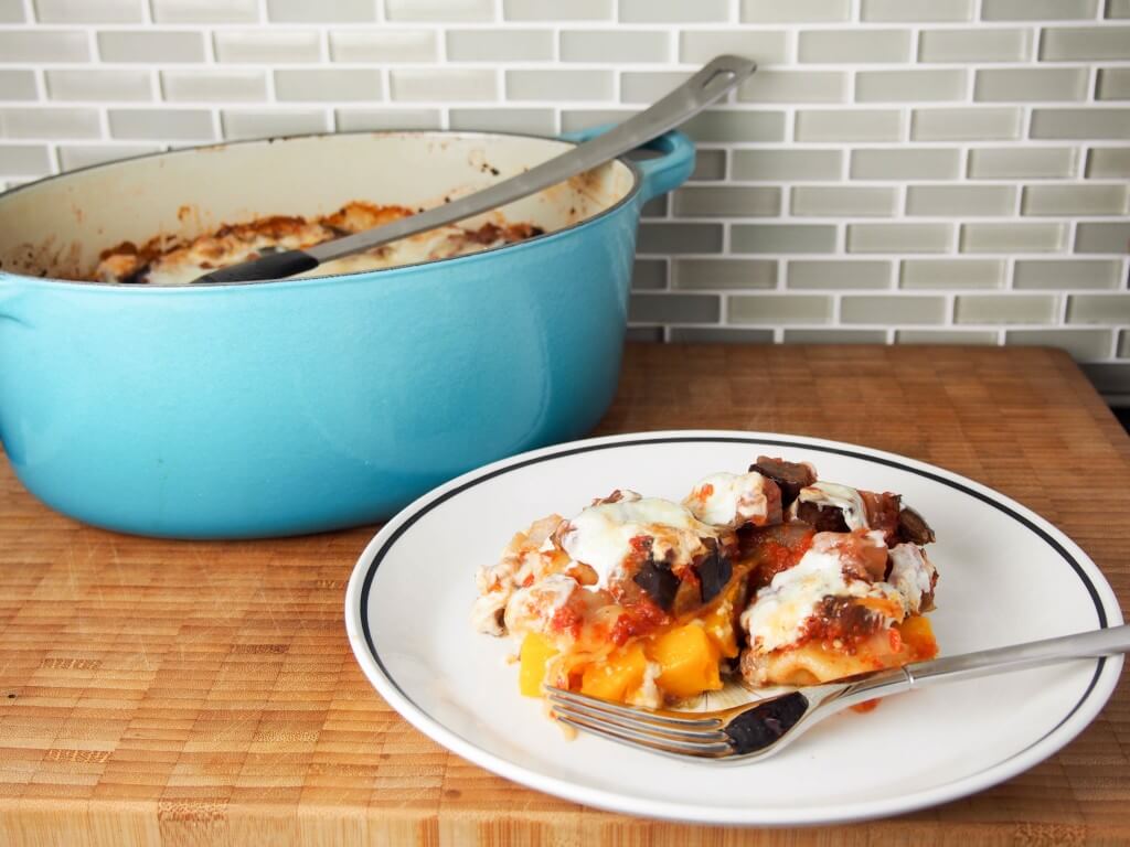 Squash and eggplant lasagna with some on plate in front of baking dish