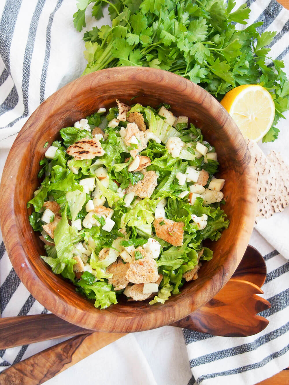 Winter fattoush salad with serving spoons to side of bowl and some of ingredients above