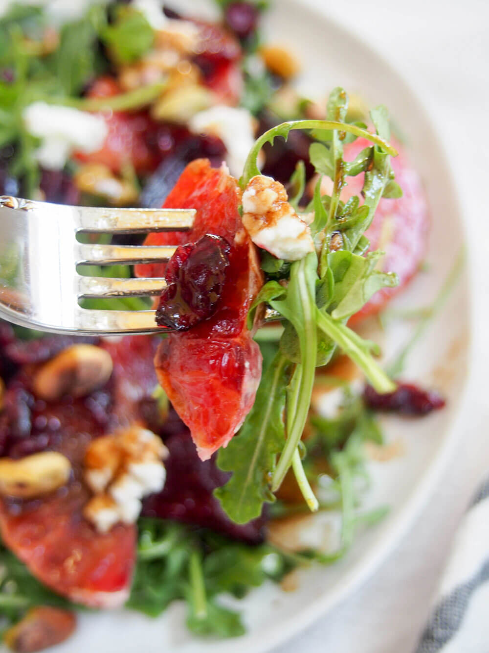 holding forkful of beet and blood orange salad over plate