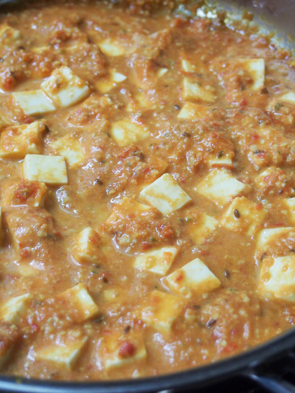 adding paneer to sauce to make paneer Makhani