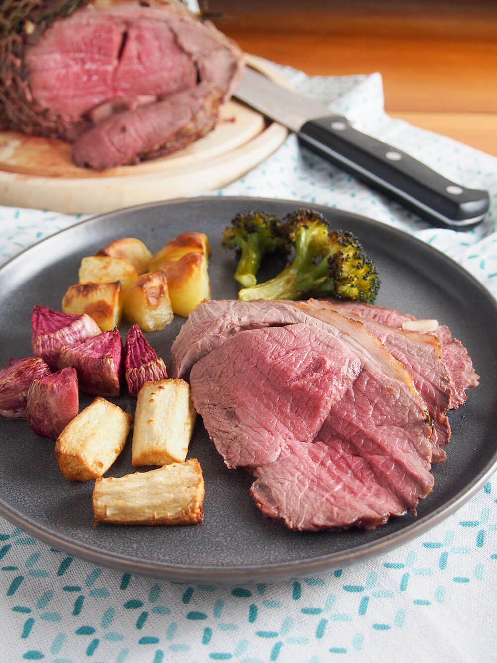 Roast lamb on plate with vegetables on the side