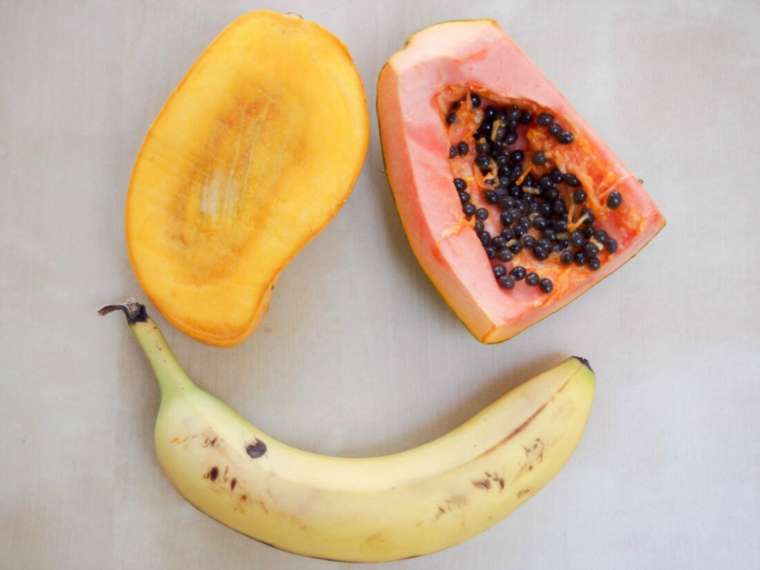 mango, papaya and banana laid out into smiling face