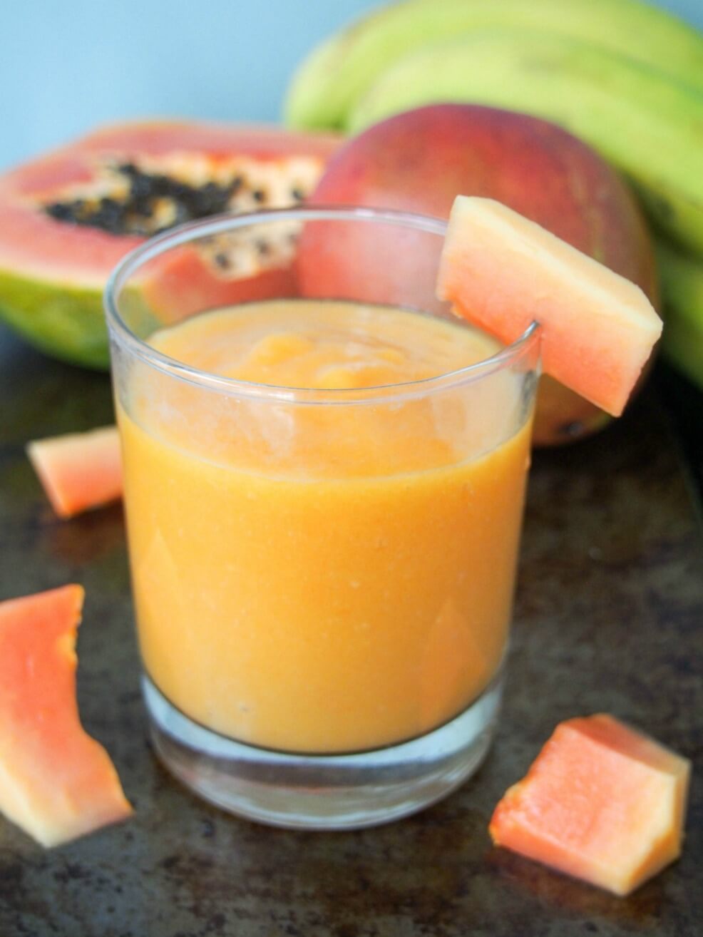 This tropical fruit smoothie is made with mango and papaya for a refreshing, tasty and vitamin-C packed drink. Made just with fruit and fruit juice, with an optional boost from flax seeds, it's also naturally dairy free. Delicious and good for you all in one. glass of tropical fruit smoothie