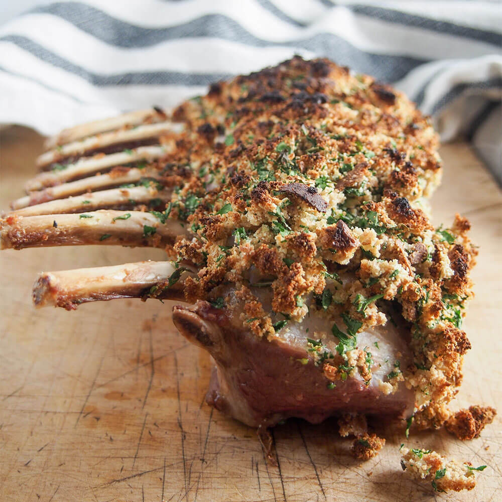 garlic herb crusted rack of lamb on board