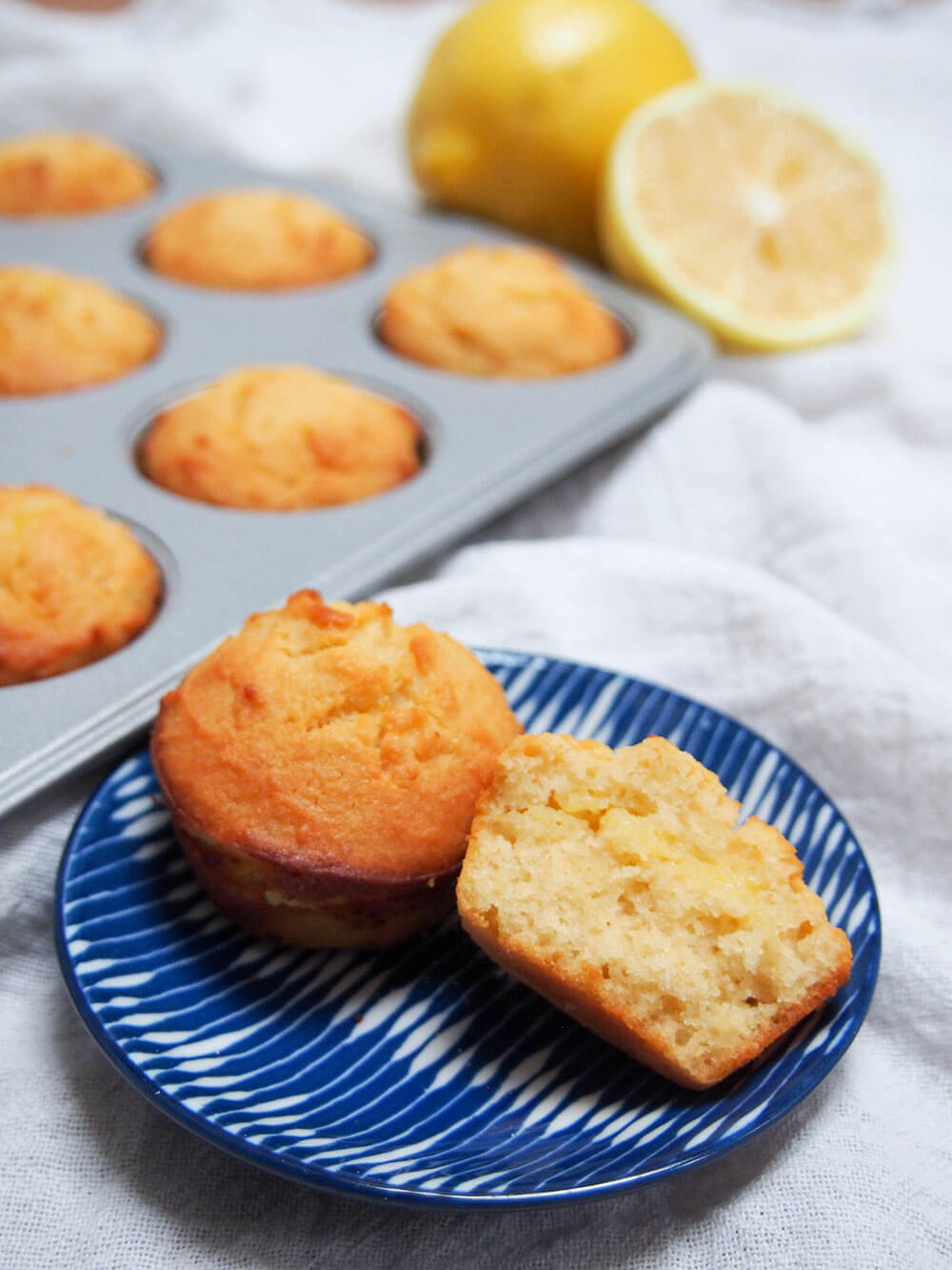 mini lemon almond flour muffins (or cupcakes) with one whole and a half on plate in front
