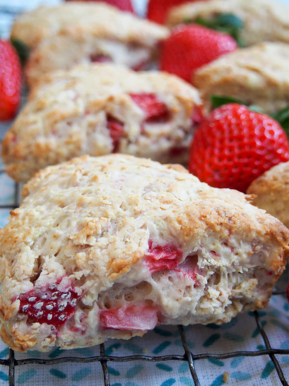 These strawberry scones are made with mascarpone and a double doze of strawberries for a wonderfully soft, fruity mouthful in every bite. Easy to make, they're a wonderful snack. strawberry scones with mascarpone in rows with strawberries in between