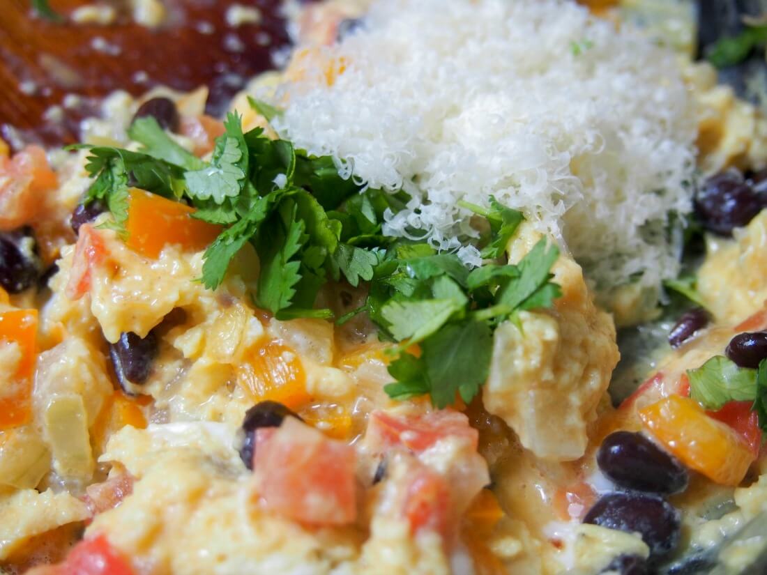 adding cilantro and cheese to egg-bean mixture