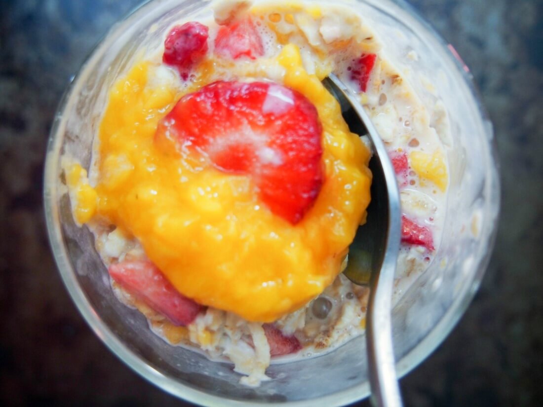 mixi ng mango and strawberry overnight oats mixing mango and strawberry overnight oats