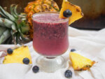 blueberry pina colada with pineapple behind