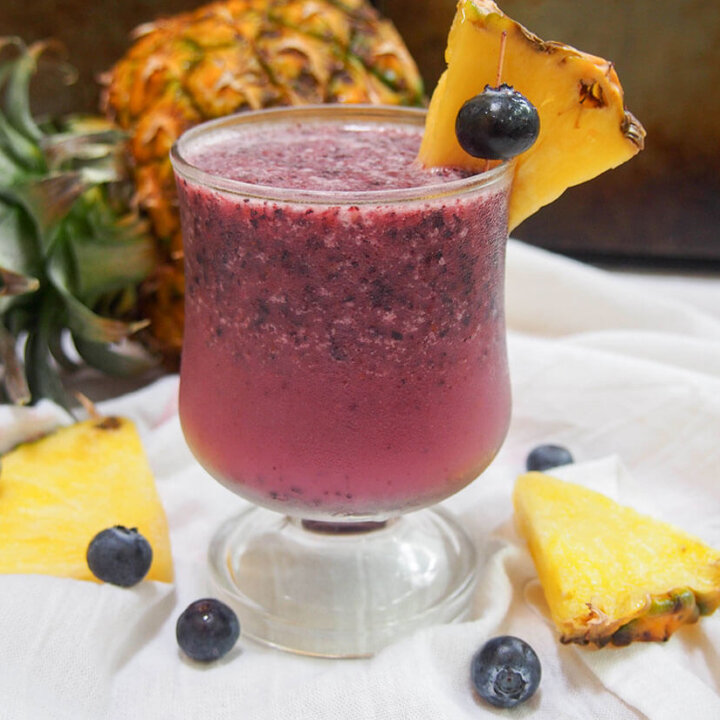 blueberry pina colada with pineapple behind