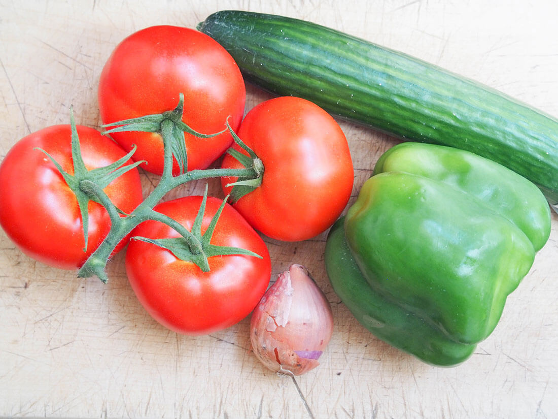 tomatoes, cucumber, green pepper and shallot on chopping board