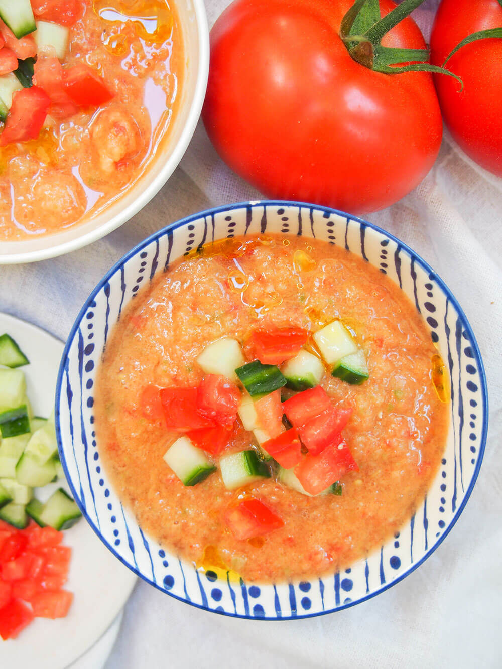 bowl of gazpacho form overhead with tomatoes above bowl