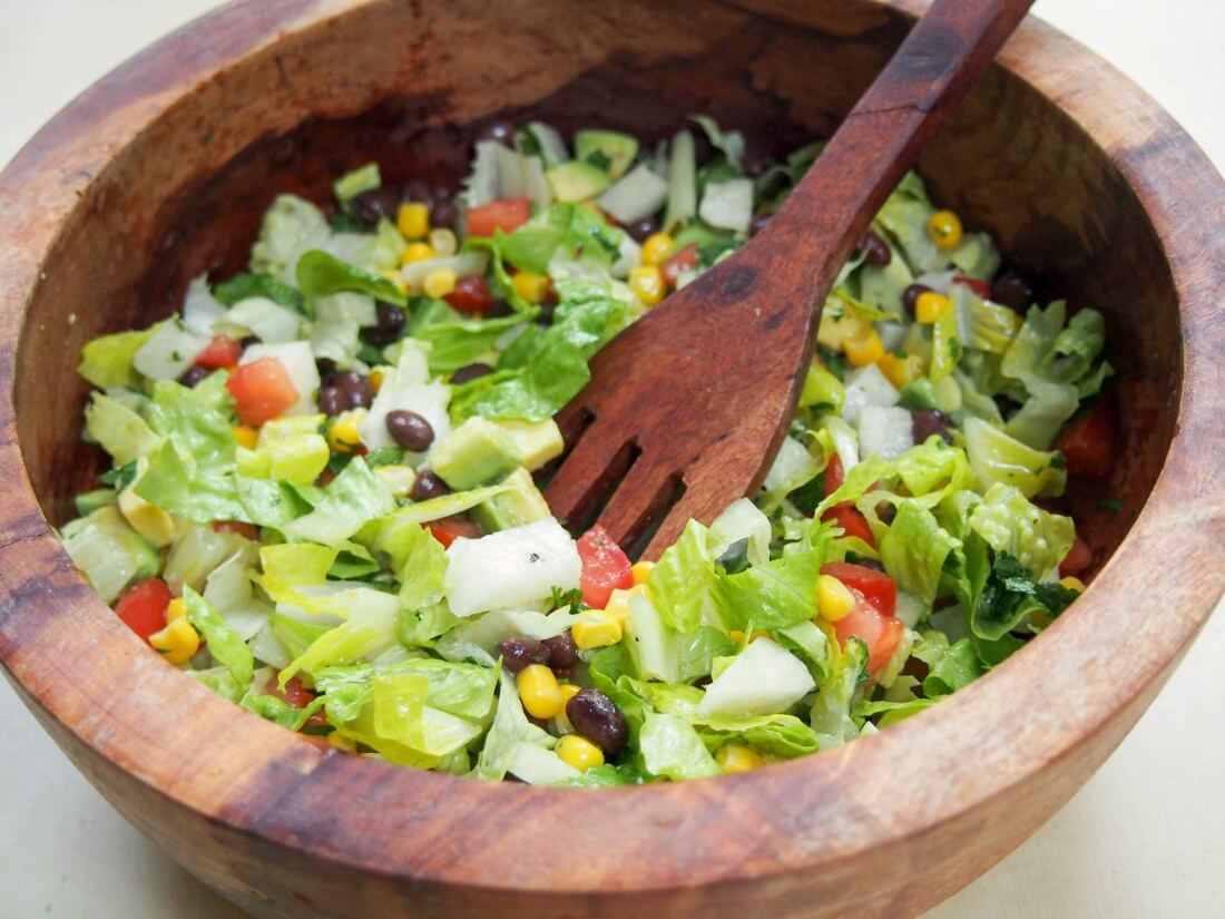 Mexican chopped salad with serving spoon in bowl