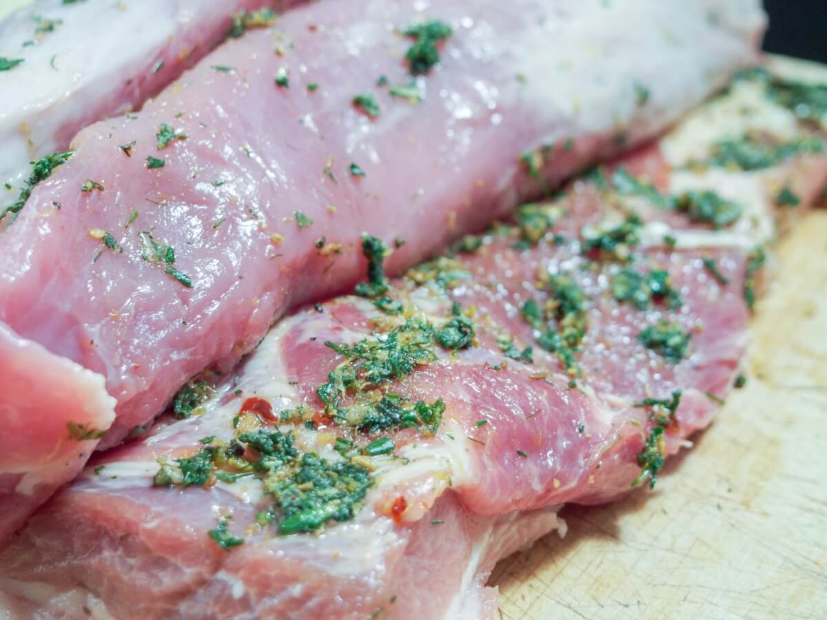 adding lemon and herb rub to pork before leaving to marinade