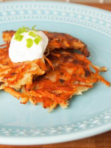 German potato pancakes (kartoffelpuffer) on plate with sour cream on top