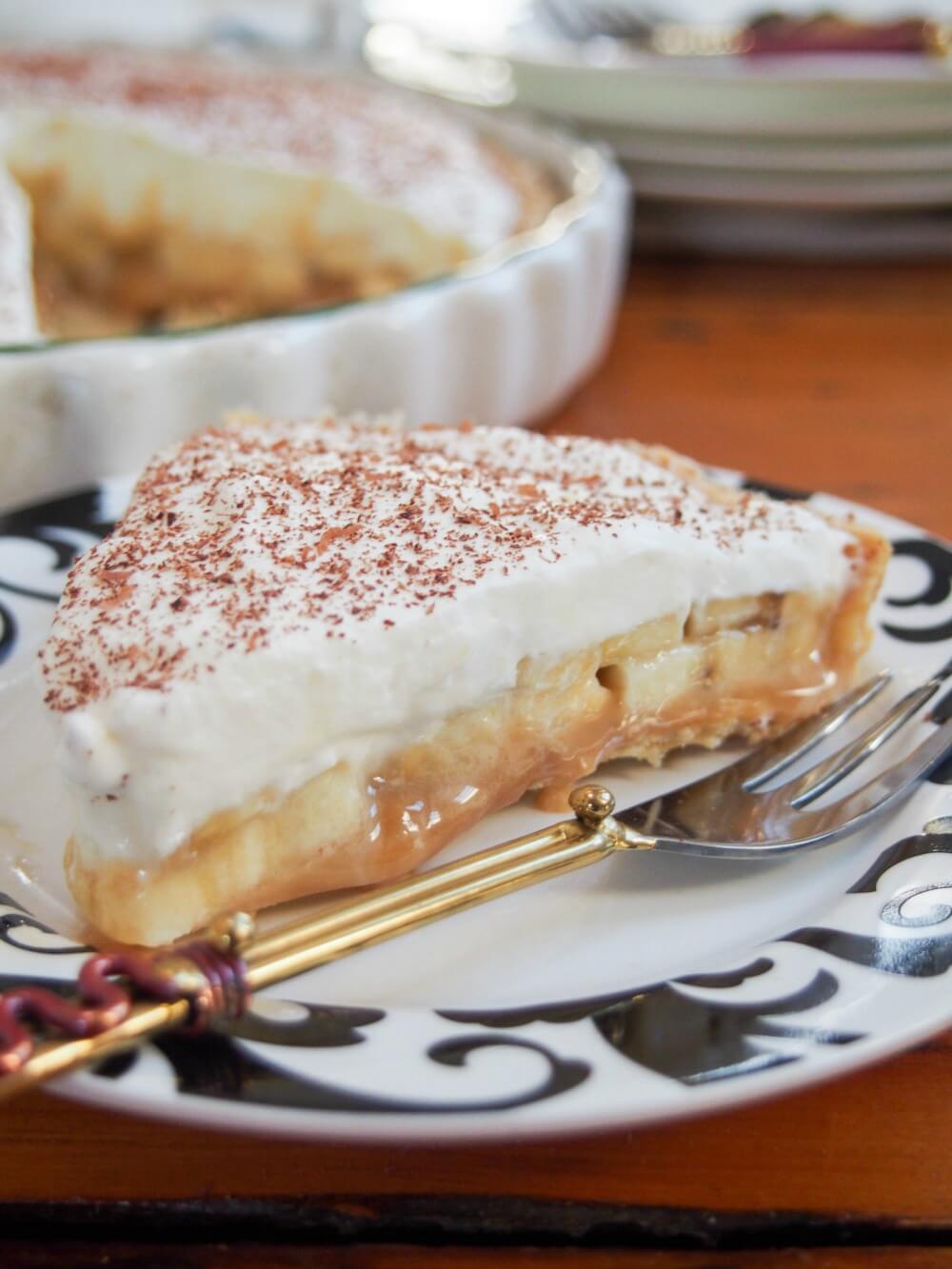 banoffee pie slice on plate with pastry fork in front