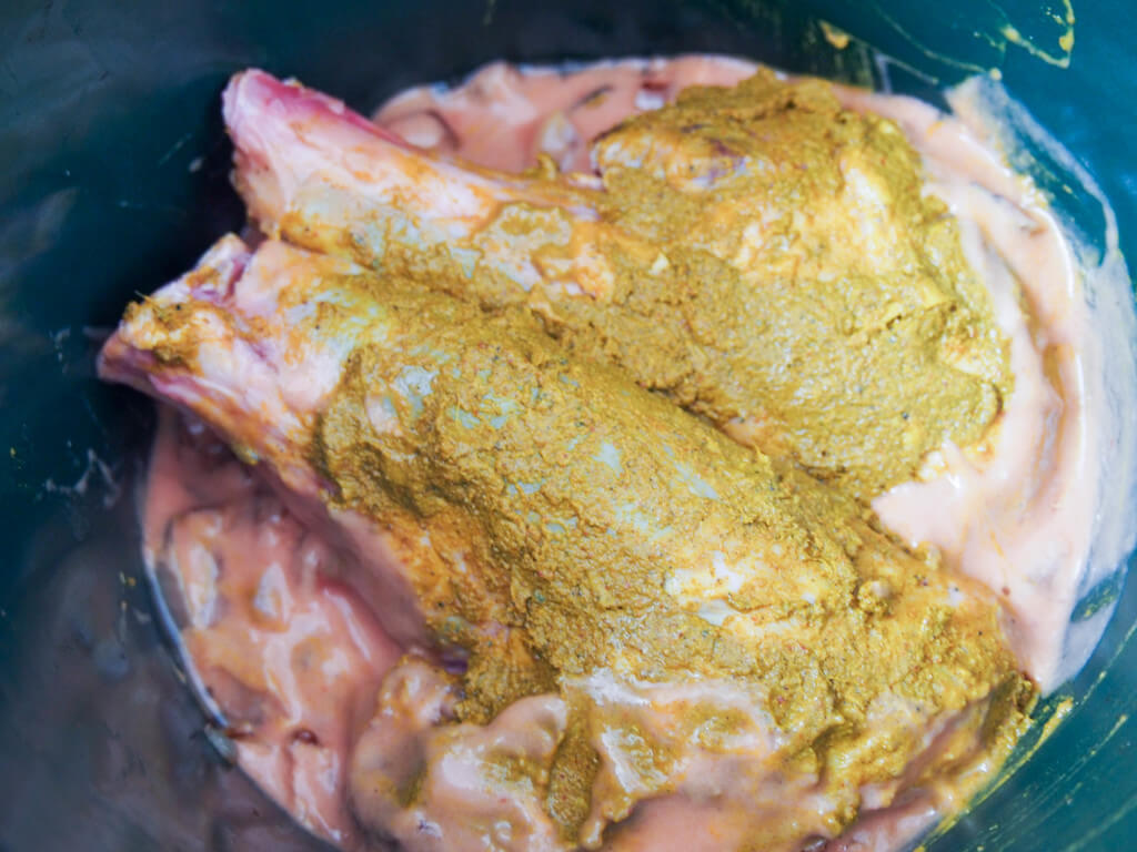 start of cooking lamb rogan josh in slow cooker lamb shanks with spice rub over yogurt sauce base in slow cooker