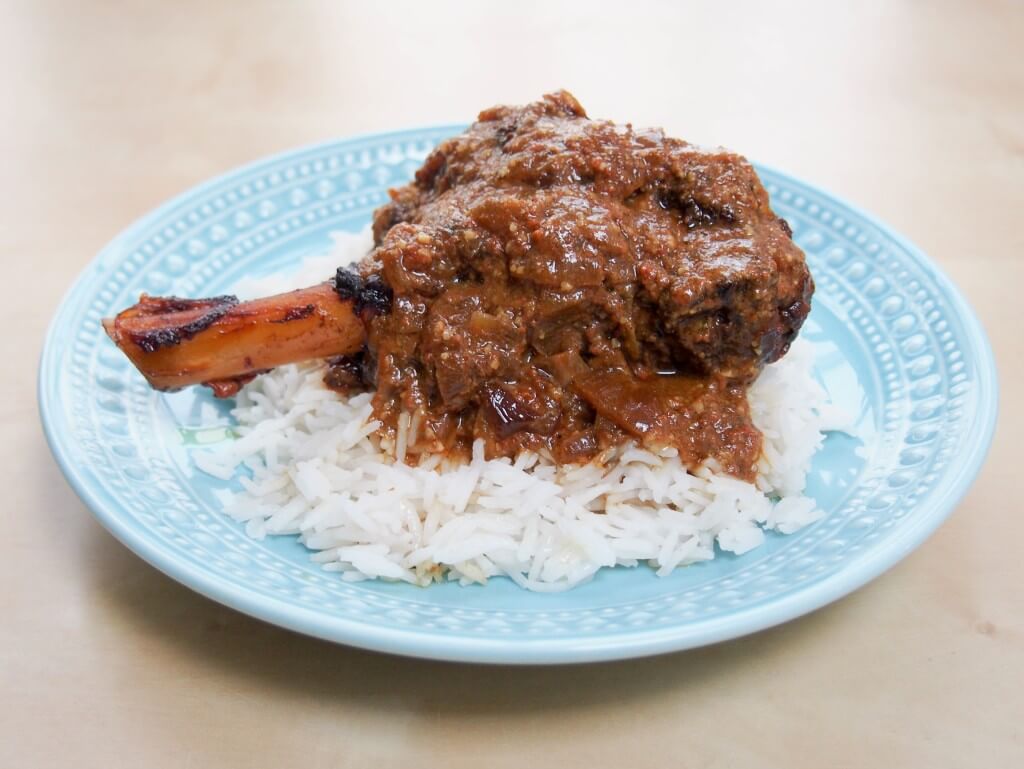 This delicious lamb rogan josh is made with lamb shanks in the slow cooker. Easy, meltingly tender & incredibly delicious: so full of aromatic Indian flavor lamb rogan josh over rice showing whole plate