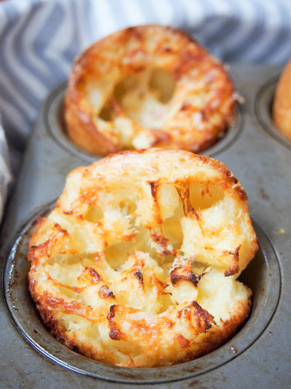 close up view of apple and cheddar cheese Yorkshire pudding with another behind