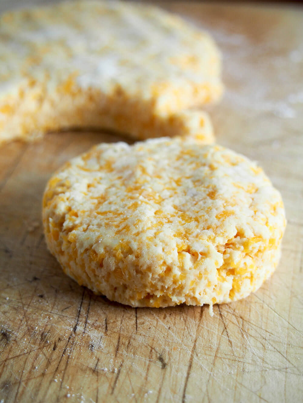 butternut squash biscuit on cutting board with rest of dough it was cut from behind
