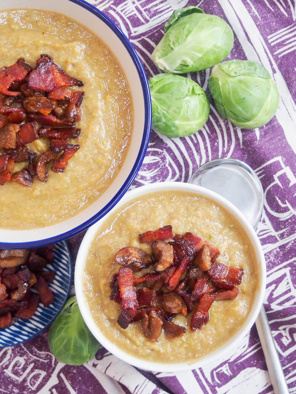 two bowls of Brussel sprout soup with crispy bacon and chestnut overhead shot