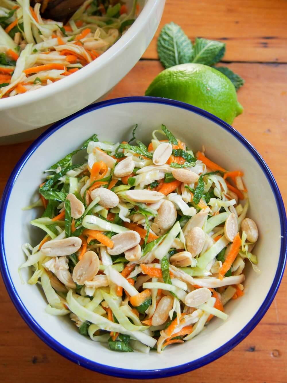 Vietnamese chicken salad is simple but delicious, a great way to enjoy leftover chicken alongside vegetables, herbs and a tasty dressing. A perfect lunch. bowl of Vietnamese chicken salad in blue-rimmed bowl with corner of other bowl to side