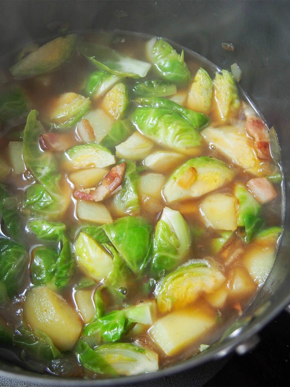 simmering Brussel sprout soup with crispy bacon and chestnut