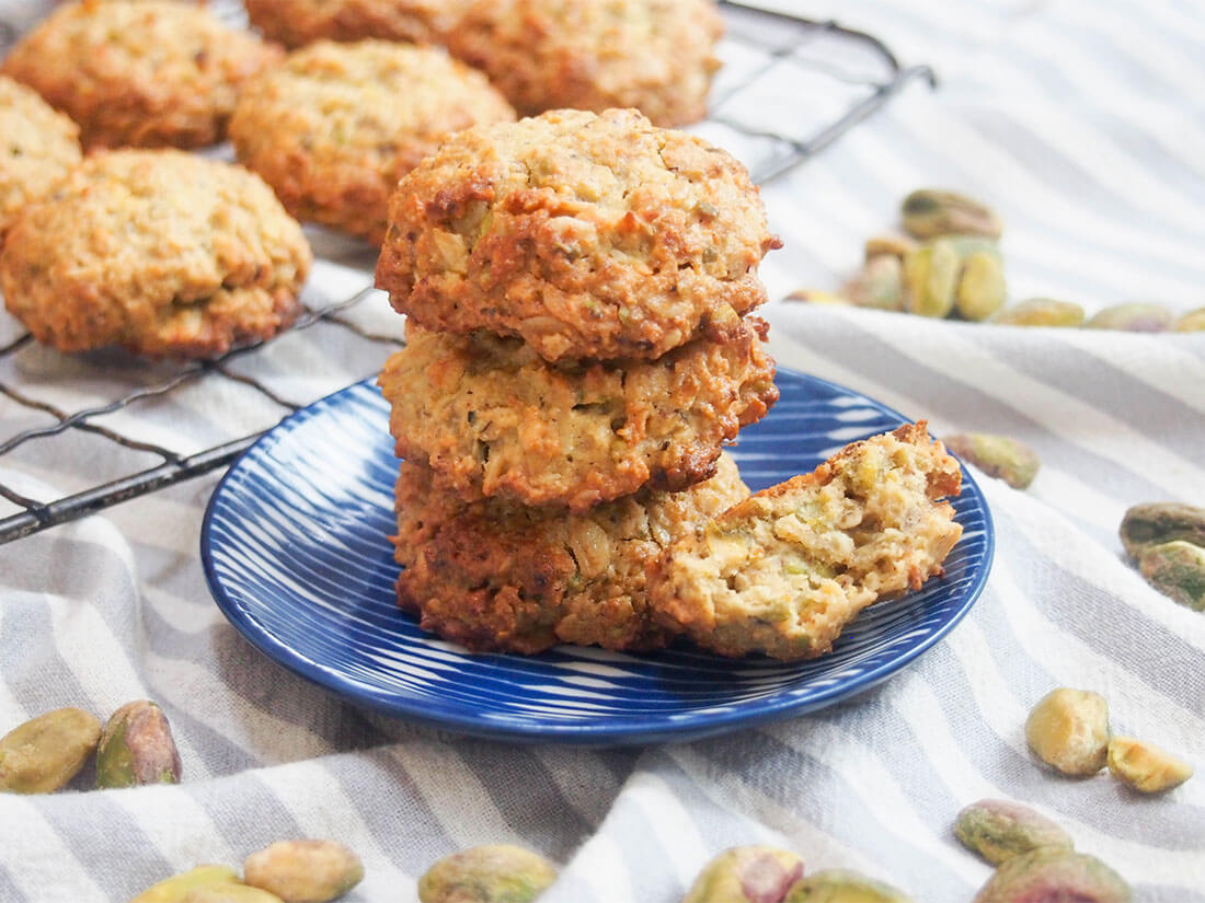 small plate of oatmeal pistachio cookies in front of more on cooling rack