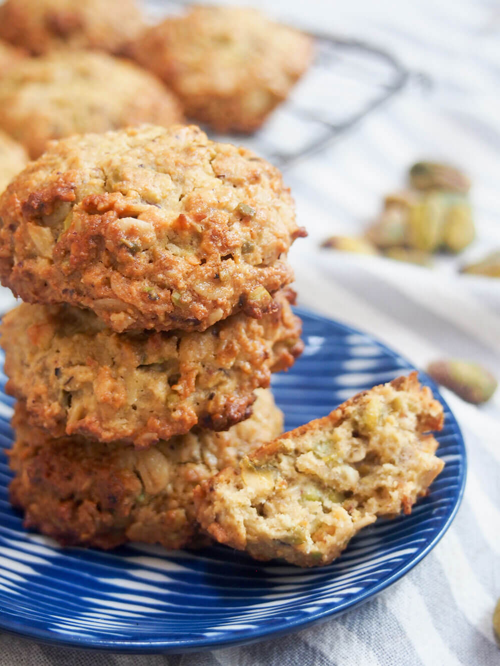 stack of oatmeal pistachio cookies up close with broken one to side