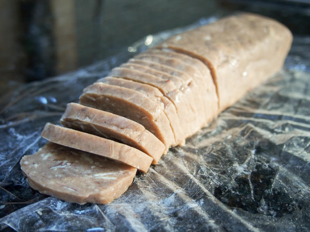 log of brunkager dough with some slices taken from it