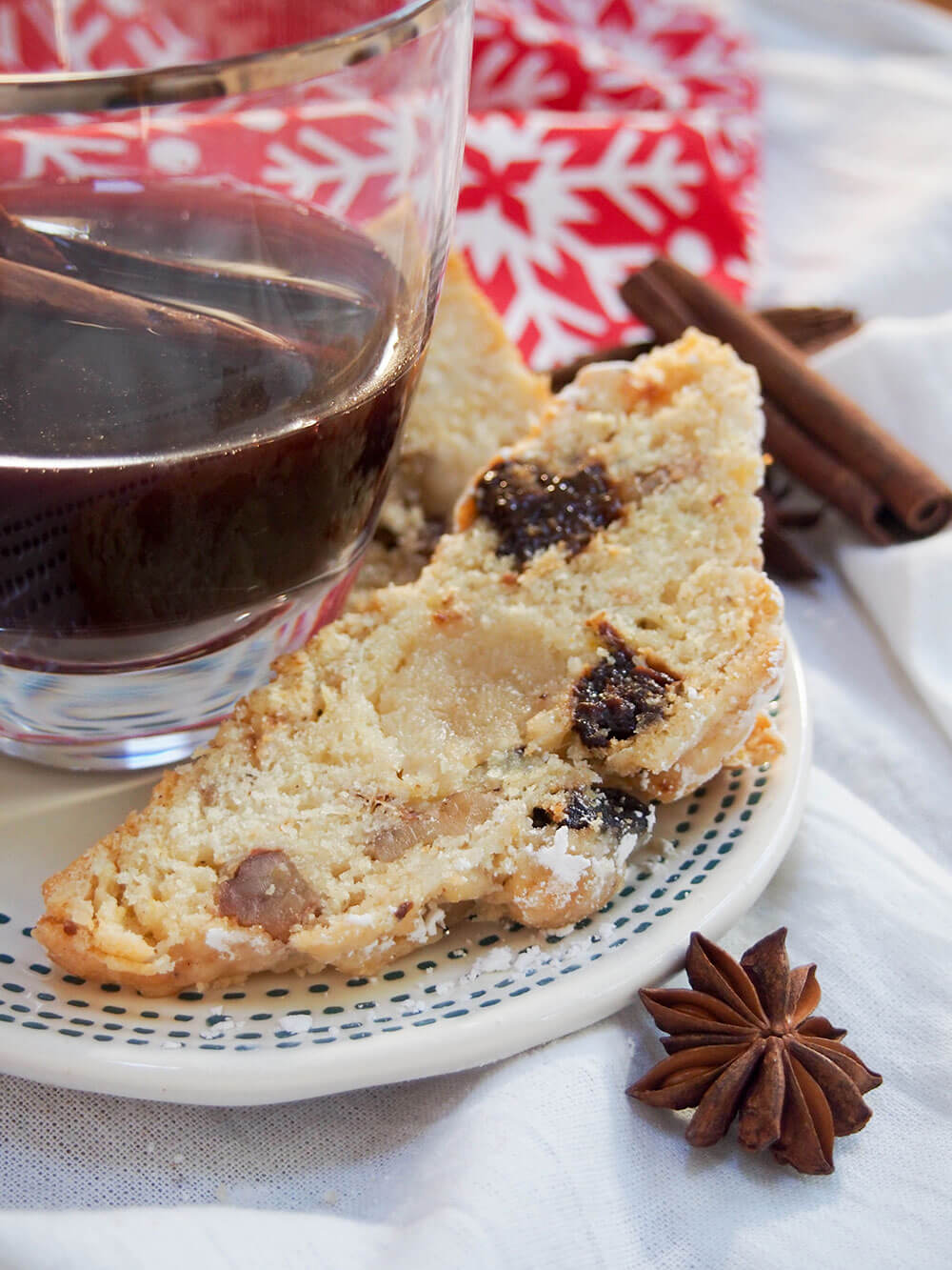 slice of traditional German stollen with dried plums beside glass of gluhwein