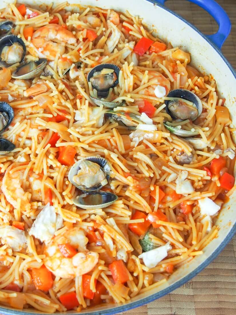 Fideua is a Catalan fish and seafood paella made with short pasta and a tomato-pepper and stock sauce base. Deliciously comforting. fideua (Catalan pasta paella) from overhead close up