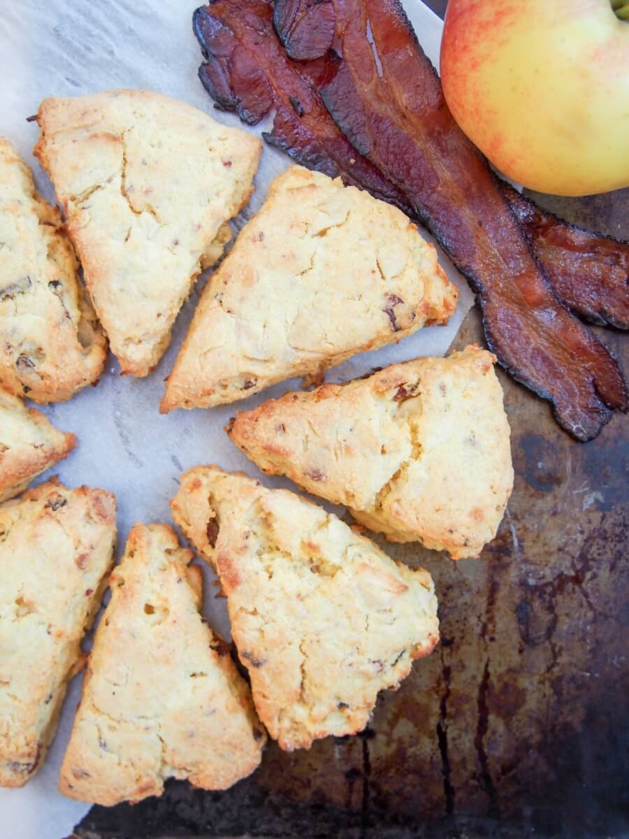 Scones viewed from overhead with bacon and part view of apple to side
