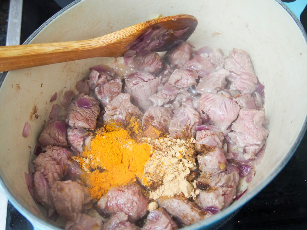 adding spices to browned lamb