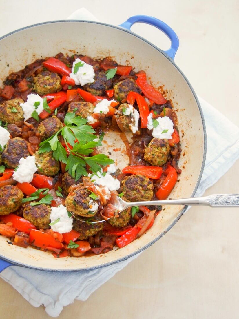 These kofte-style lamb meatballs are delicious with herbs, spices and pine nuts in them, made even better served in a tomato-pepper sauce with a feta-yogurt topping. 