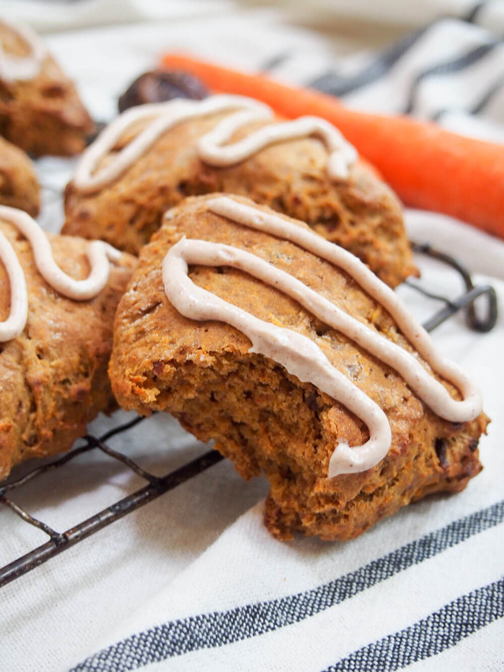 carrot cake scone with bite taken out resting against cooling rack