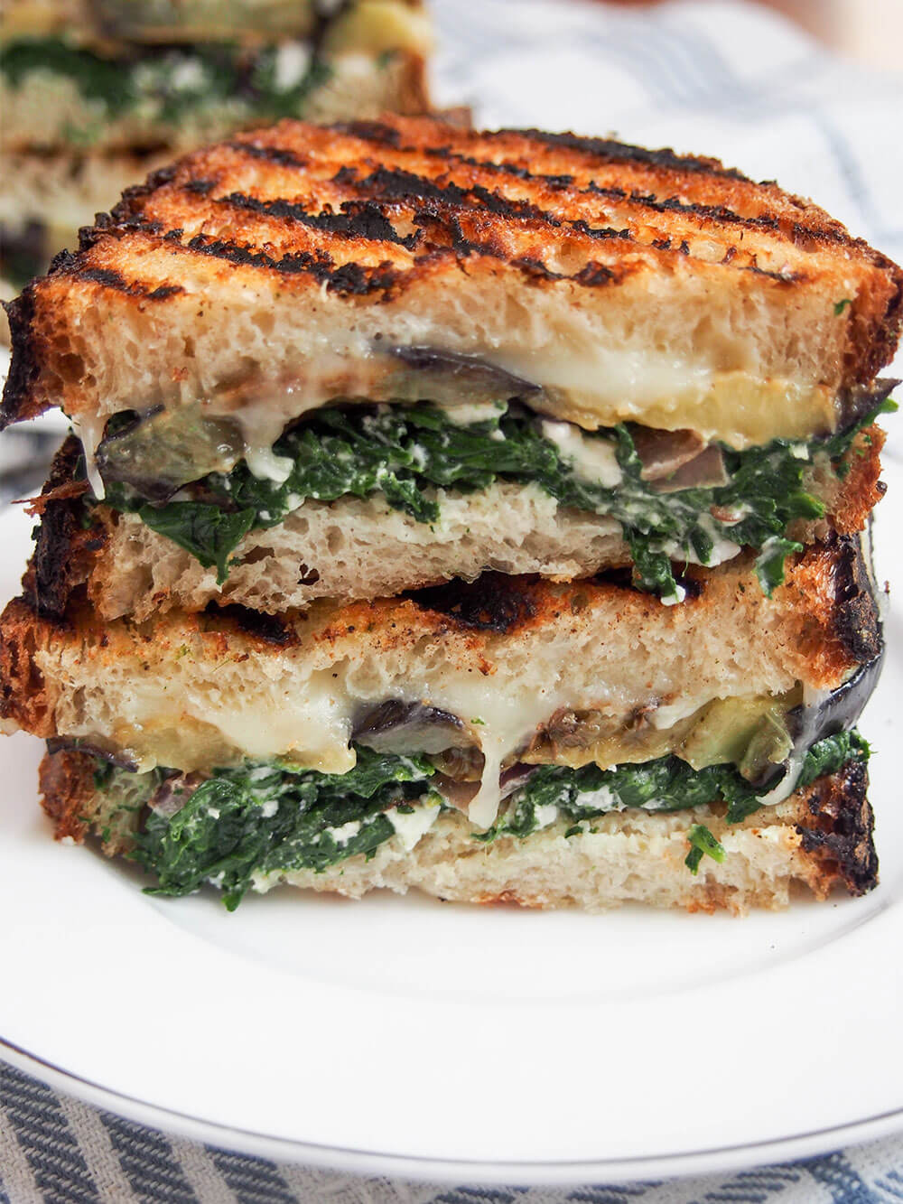 This eggplant spinach grilled cheese sandwich draws on Greek flavors for a deliciously cheesy vegetarian grilled cheese. It's hearty and filling, but without feeling too heavy since it's veggie-packed too! Eggplant spinach grilled cheese sandwich stacked on top of each other