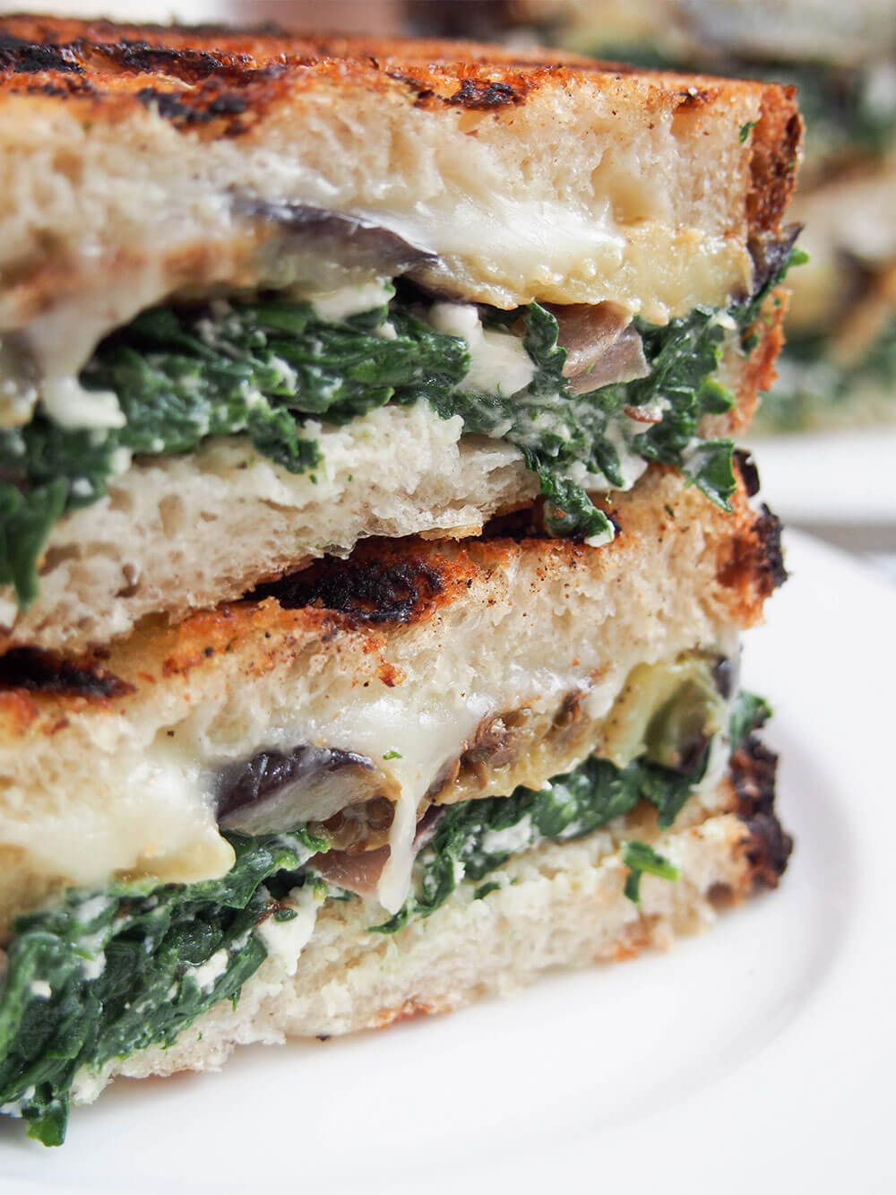 This eggplant spinach grilled cheese sandwich draws on Greek flavors for a deliciously cheesy vegetarian grilled cheese. It's hearty and filling, but without feeling too heavy since it's veggie-packed too! Eggplant spinach grilled cheese sandwich close up