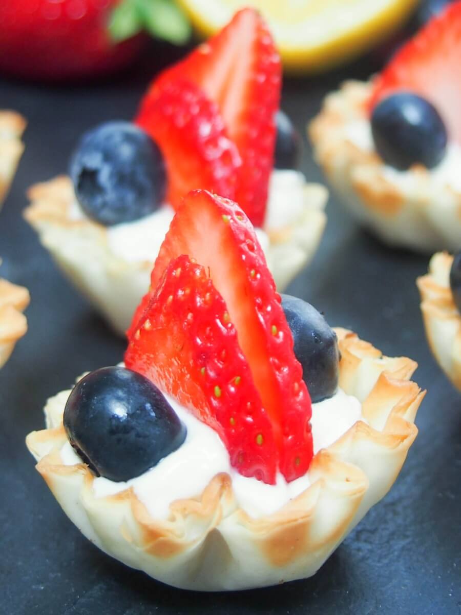 Berry phyllo cups with lemon cheesecake cream close up on one bite