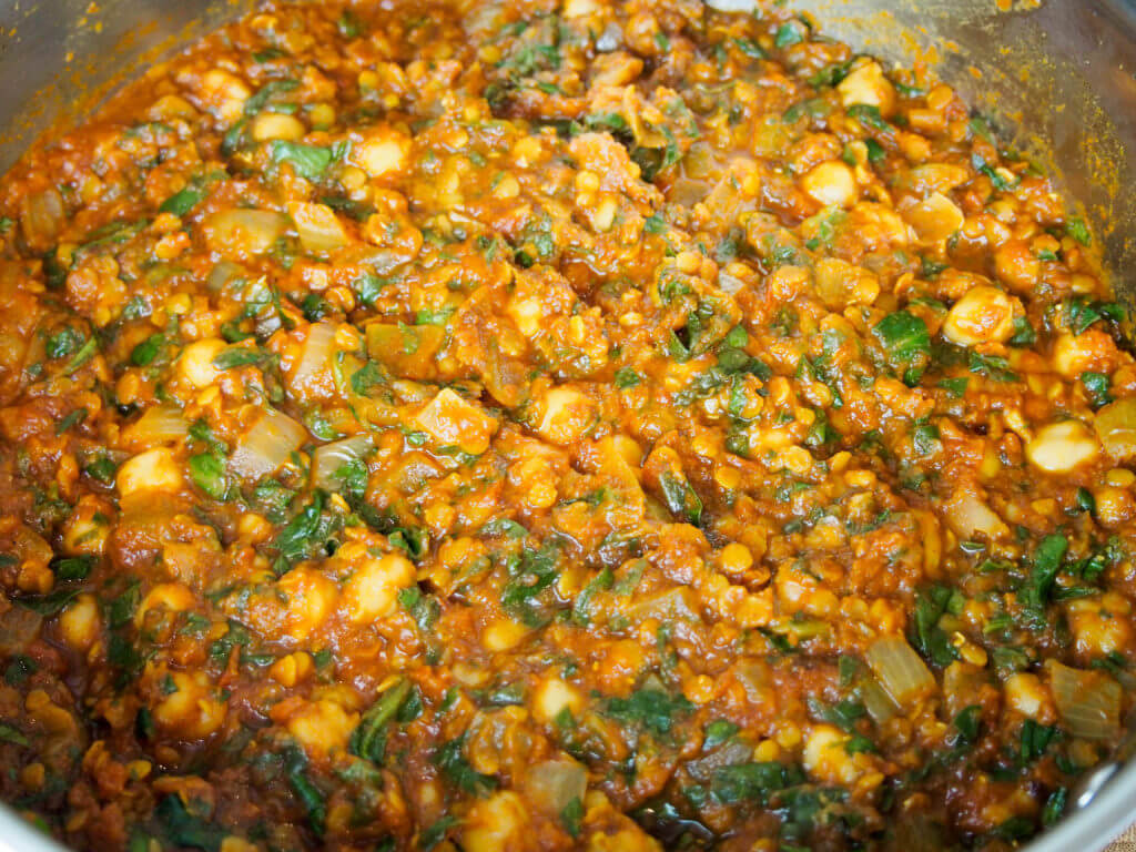 making chickpea, lentil and spinach curry