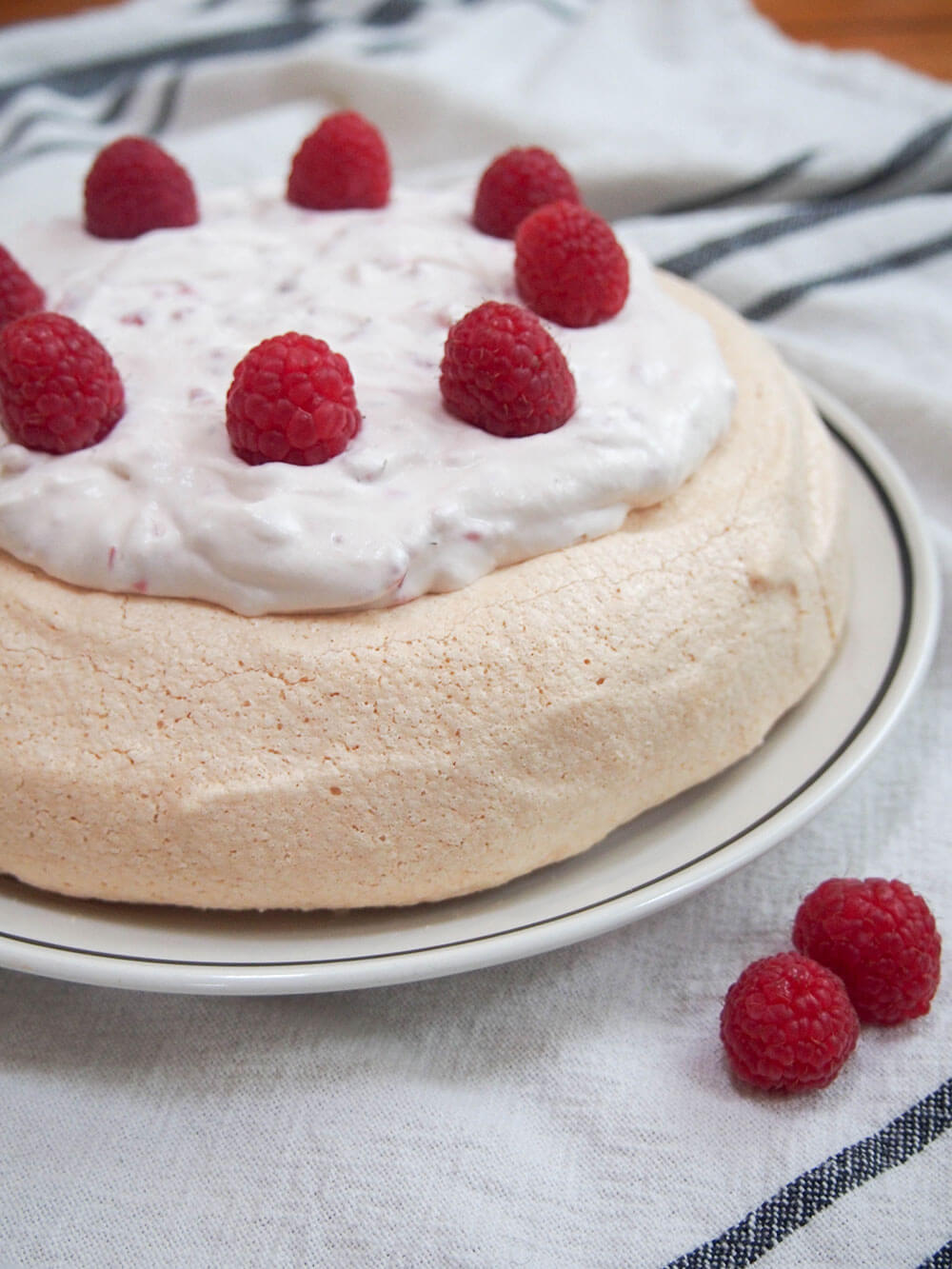pavlova with raspberries and cream on plate