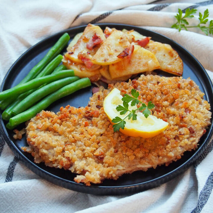 Wiener schnitzel on plate with potatoes and beans
